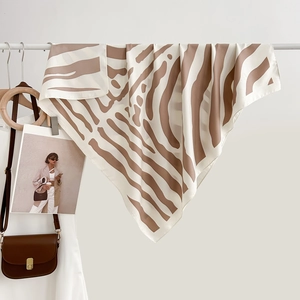 Écharpe en soie à motif zébré sur un support blanc dans un décor de style minimaliste