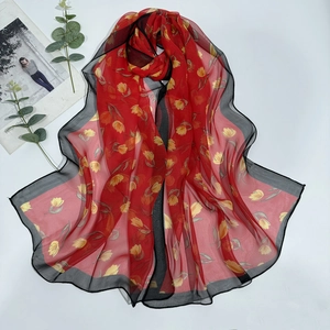 Detail of red tulip print georgette scarf with black wavy edges and sheer fabric texture