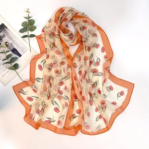 Detail of tulip floral print on georgette silk scarf with vibrant orange borders