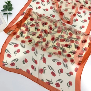 Detail of Georgette long scarf featuring red tulip prints and orange border accents
