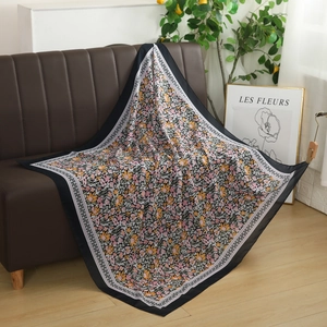 Floral voile square headscarf draped over a sofa showing soft texture and drape