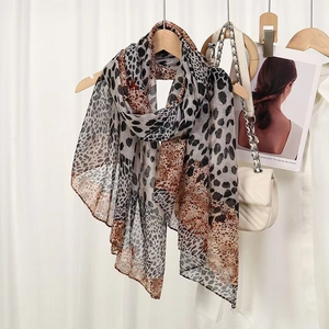 Long leopard print scarf in sheer voile fabric draped on a hanger with stylish accessories