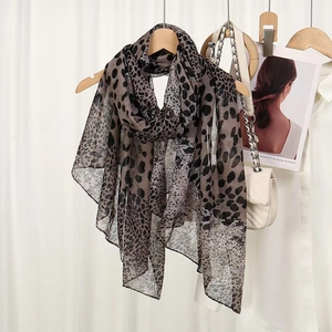 Leopard print leopard scarf in lightweight bali yarn draped on a wooden hanger with bag