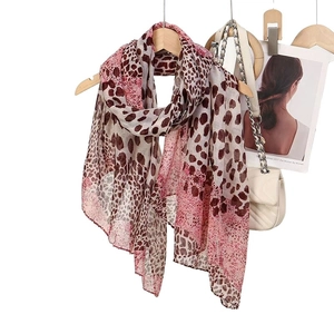 Leopard print patchwork scarf in lightweight pink and brown voile, draped on wooden hanger