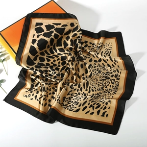 Detailed view of leopard print silk square scarf with elegant satin luster and black border