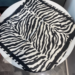 Detailed view of the black and white zebra print satin scarf on a white surface