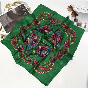 Close-up of emerald green ethnic floral scarf with red poppies and blue pattern