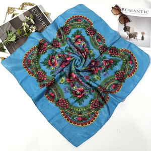 Detail of blue folk style scarf with rose print and shimmering gold thread accents