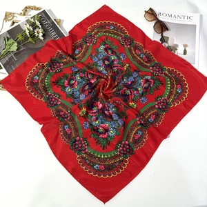 Flat lay of red ethnic floral scarf with roses, styled with a magazine and sunglasses