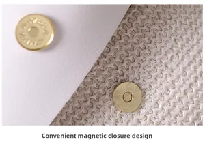 Detail of white woven handbag showing golden metal magnetic snap closure system