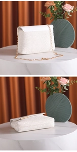 Detail view of a white woven shoulder bag with golden chain strap and elegant texture