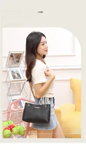 Close-up of black V-quilted faux leather shoulder bag with elegant gold chain strap
