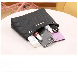 Detail view of black chevron quilted handbag showing capacity for phone and wallet