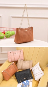 Detail view of colorful embroidered shoulder bags with chain straps and V-shaped stitching