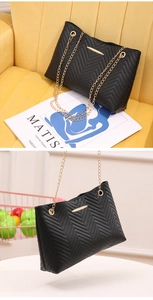 Close-up of black chevron quilted tote bag with golden metal chain strap and details