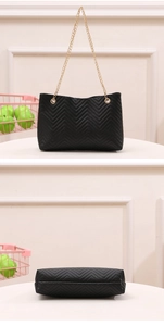 Detail view of black chevron quilted shoulder bag with golden chain straps and bottom structure