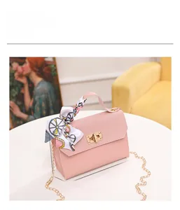 Detail of pink PU leather handbag with woven texture, metal lock, and silk scarf handle