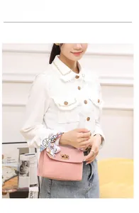 Pink leather handbag detail featuring floral silk scarf handle and golden metal turn-lock clasp
