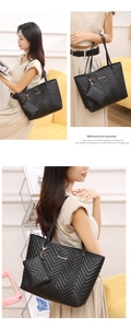 Dettaglio della borsa tote nera trapuntata chevron e mini pochette coordinata sul divano