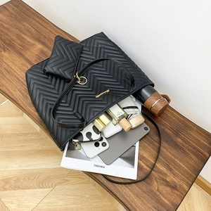 Set borsa tote nera trapuntata a V con portamonete che mostra la grande capienza