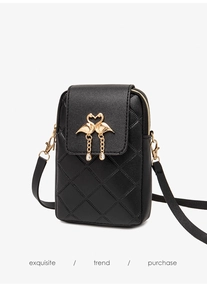 Detailed view of black quilted phone bag with gold flamingo heart buckle and charms
