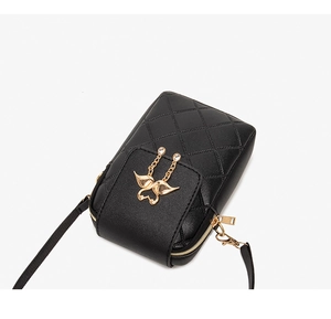 Detail of black quilted leather phone bag with gold butterfly charm and zipper