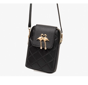 Close-up of quilted black crossbody phone bag with golden heart-shaped flamingo buckle