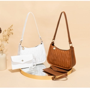 Detailed view of quilted faux leather shoulder bags with matching coin purses on a gold tray
