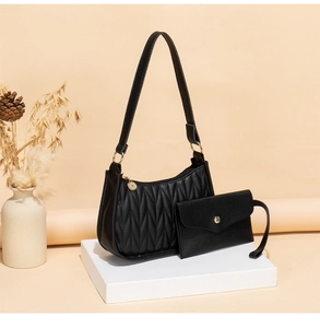 Detail of black quilted shoulder bag set with gold hardware and mini envelope pouch