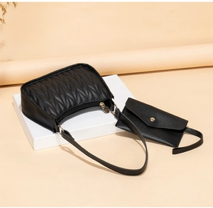 Close-up of black quilted hobo bag with V-shaped texture and matching small coin purse