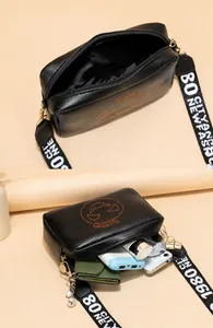 Detailweergave van de grote binnenruimte van een zwarte crossbodytas met pompoenborduursel