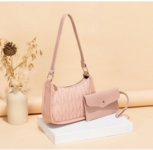 Pink quilted shoulder bag set with small pouch on minimalist studio display stand