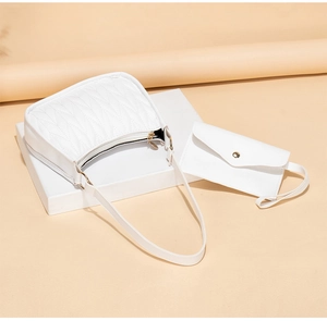 Detail view of white quilted shoulder bag set with matching envelope pouch on geometric stand