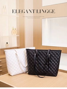 Detail view of black and white quilted leather tote bags in an elegant boutique display