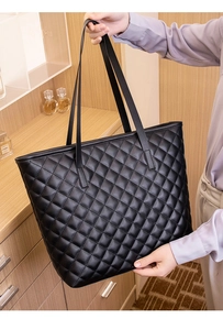 Macro detail of high-quality quilted leather texture on large black tote bag