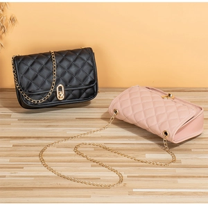 Close-up of quilted crossbody bags in pink and black with golden chain straps and locks