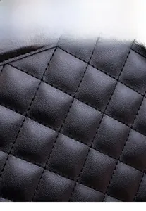 Macro detail of high-quality black quilted fabric with fine texture and stitching