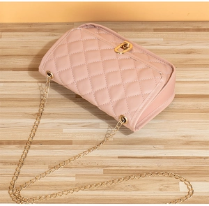 Detailed view of quilted faux leather crossbody bag with golden twist lock and chain strap