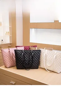 Quilted tote bags in five different colors displayed on a wooden counter top