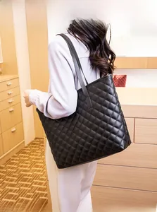Quilted black tote bag shown on model highlighting spacious design and classic diamond pattern