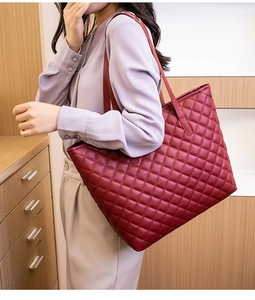 Detail of red quilted leather tote bag showing large capacity and soft texture