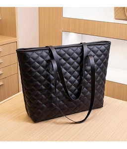 Close-up of black quilted tote bag showing fine stitching and high-quality leather texture