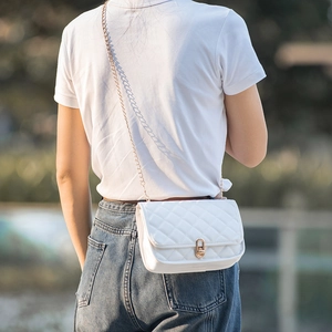 White quilted crossbody bag with gold chain strap shown on model for a stylish look
