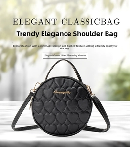 Detail of elegant black circular bag featuring heart quilted texture and golden hardware