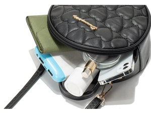 Interior view of round quilted heart bag showing capacity for phone, wallet and cosmetics