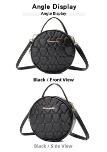 Close-up of black round crossbody bag with heart quilting and golden logo detail