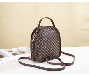 Detail view of brown arched crossbody bag with circular print and top handle