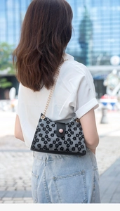Vue arrière d'un mannequin portant un sac à fleurs noir avec chaîne dorée