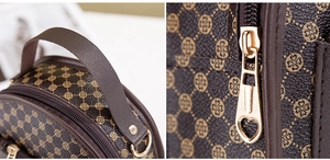 Detail of clover print leather backpack featuring a gold heart-shaped metal zipper pull