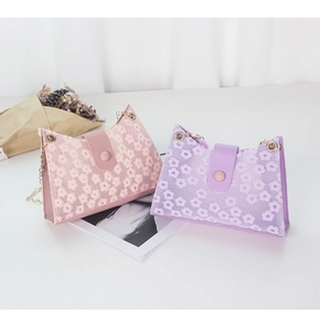 Détail de mini sacs en dentelle florale rose et violette avec fines chaînes en métal